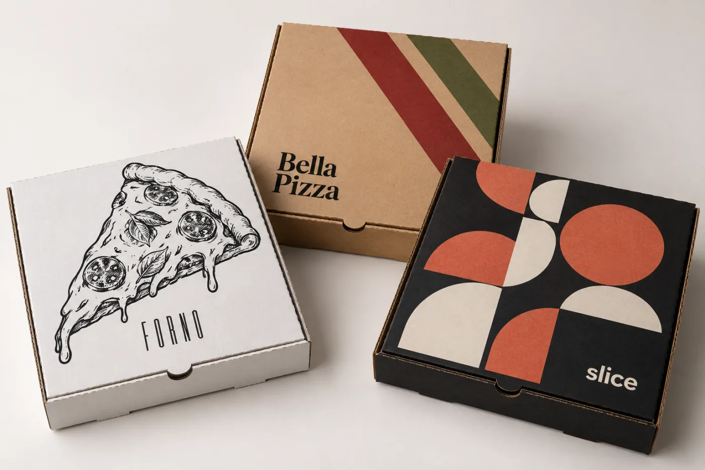 Three printed pizza boxes — a white box with a hand-drawn line illustration, a kraft box with diagonal red and olive stripes, and a charcoal box with a bold geometric pattern