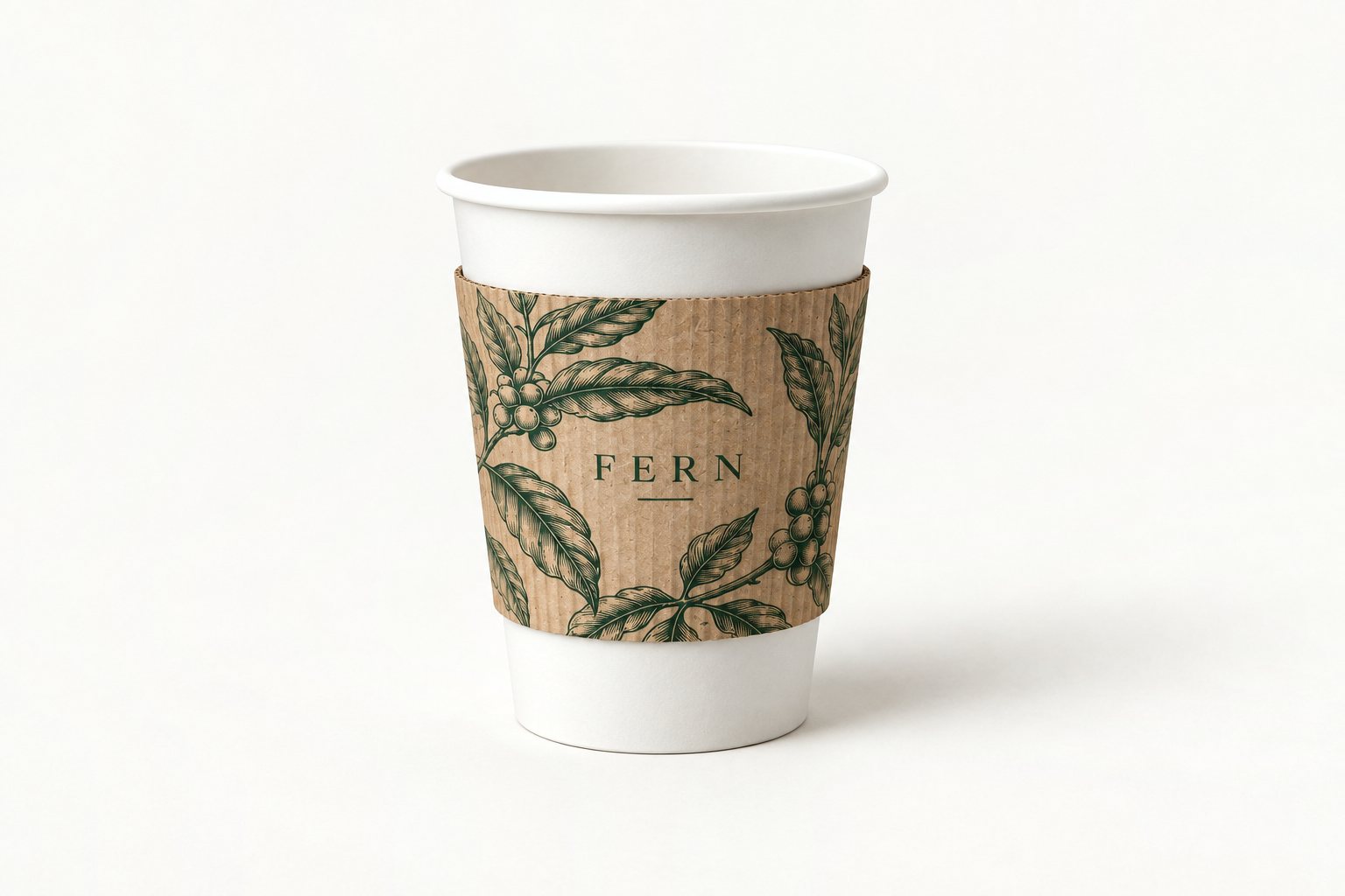Corrugated kraft cup sleeve printed with the “FERN” botanical design, fitted on a plain white cup